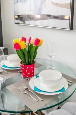 a glass table with plates and a vase of flowers at Apartment in the James South Neighborhood in Hamilton