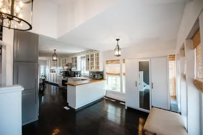 a kitchen with white cabinets and a hard wood floor at Hamilton's Beach House Stunning Lake Views! Modern Open concept HotTub,firepit, 3BR in Hamilton