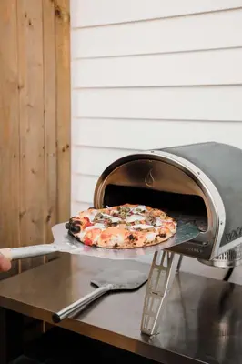 a pizza is being cooked in an oven at The Old Homestead - Gorgeous backyard right in The Heart of Picton in Picton