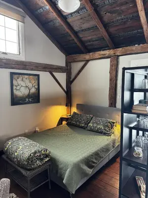a bedroom with a bed and a chair at The Farm Shed Guelph Elora in Guelph