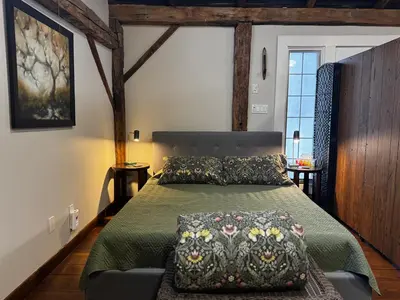 a bedroom with a bed with a green bedspread at The Farm Shed Guelph Elora in Guelph
