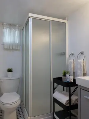 a bathroom with a shower with a toilet and a sink at Charming Bloor West Retreat in Toronto