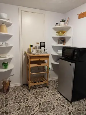 a room with a small desk next to a refrigerator at Charming Bloor West Retreat in Toronto