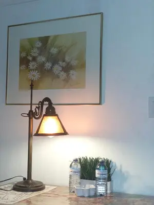 a lamp on a table with a picture on the wall at Charming Bloor West Retreat in Toronto