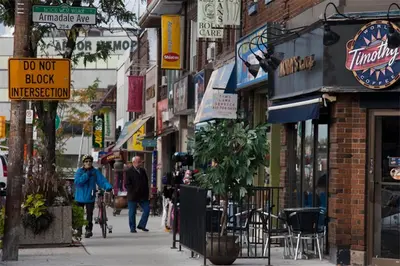 a city street with people walking down the street at Charming Bloor West Retreat in Toronto