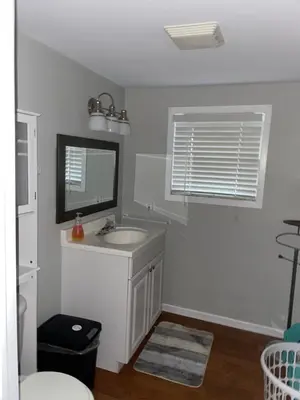 a white bathroom with a sink and a mirror at Swing Bridge Cottage on Lake Simcoe - Waterfront in Brechin