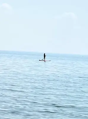 a person on a paddle board in the water at Swing Bridge Cottage on Lake Simcoe - Waterfront in Brechin