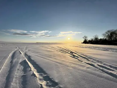 a snow covered field with footprints in the snow at Swing Bridge Cottage on Lake Simcoe - Waterfront in Brechin