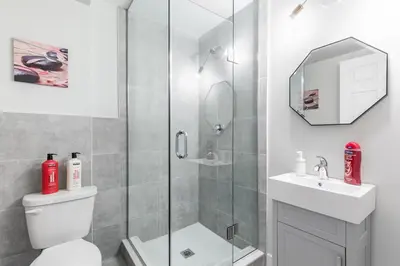a bathroom with a shower and a toilet and a sink at 1BR Basement Condo - James Street in Hamilton