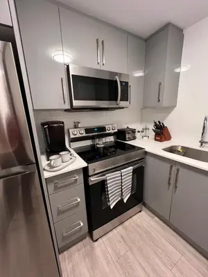 a small kitchen with a stove and a microwave at Niagara Getaway across Fallsview in Niagara Falls
