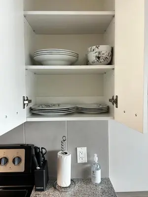 a kitchen cabinet with plates and dishes in it at 1-bedroom condo near University of Waterloo in Waterloo