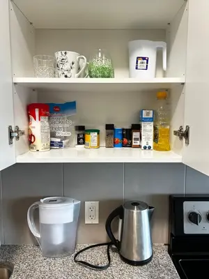 a kitchen counter with a cupboard filled with food items at 1-bedroom condo near University of Waterloo in Waterloo