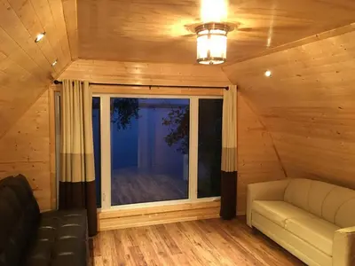 a living room with a couch and a large window at Sandy Shore Cottages Luxury Resort on Rice Lake in Harwood