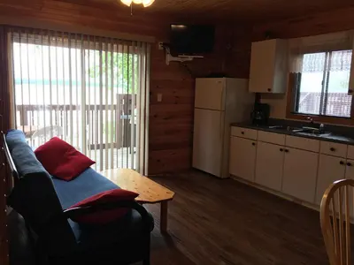 a living room with a couch and a table at Sandy Shore Cottages Luxury Resort on Rice Lake in Harwood