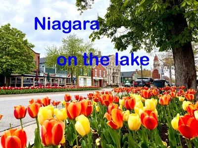 a sign that says nyssaza on the lake with flowers at Barkerhouse 2# unit-heart of oldtown in Niagara on the Lake