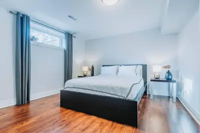 a bedroom with a bed and a large window at Luxurious and Spacious 4BR Home Near Downtown in Burlington