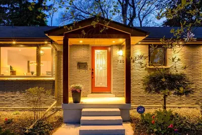 a brick house with a red door and stairs at Luxurious and Spacious 4BR Home Near Downtown in Burlington