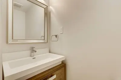 a bathroom with a white sink and a mirror at Luxurious and Spacious 4BR Home Near Downtown in Burlington
