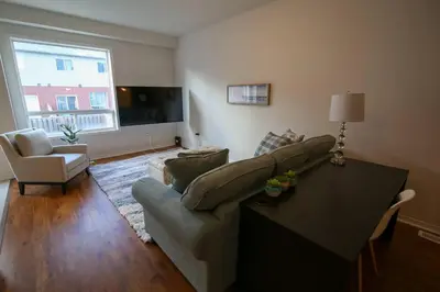 a living room with a couch and a table at Townhome Steps From Lake Ontario in Hamilton