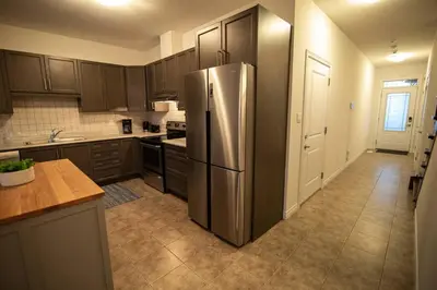 a kitchen with a stainless steel refrigerator in it at Modern & Cozy Retreat Lake Ontario & Wine Country in Grimsby