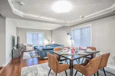 a living room with a table and chairs and a couch at Stylish 4BR Home 20 Mins from YYZ in Mississauga