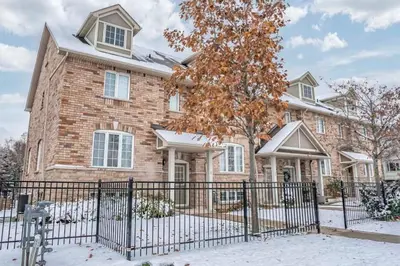 a brick house with a fence in the snow at Stylish 4BR Home 20 Mins from YYZ in Mississauga
