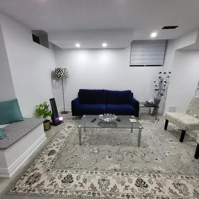 a living room with a blue couch and a table at Bright 2 Bedroom Basement Apartment in Angus in Angus