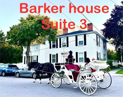 a horse drawn carriage in front of a white house at Barker House 3# Suite-heart of oldtown in Niagara on the Lake