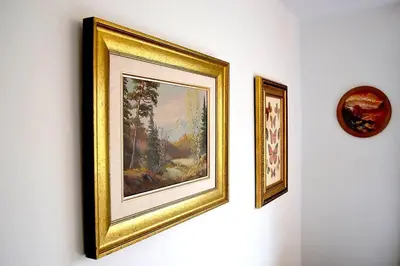 two framed paintings on a wall next to a clock at Cellar House NOTL - Entire Home in the Heart of Niagara-on-the-Lake in Niagara on the Lake