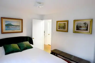 a bedroom with a bed and two pictures on the wall at Cellar House NOTL - Entire Home in the Heart of Niagara-on-the-Lake in Niagara on the Lake