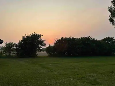 a sunset over a field with trees in a field at 4 Bedrms, Indoor HotTub, Wineries & Niagara Falls in Beamsville