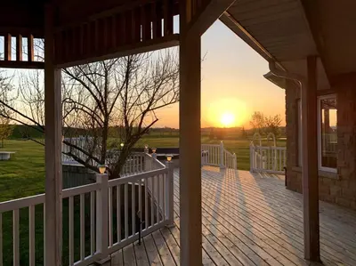 a porch of a house with the sunset in the background at 4 Bedrms, Indoor HotTub, Wineries & Niagara Falls in Beamsville
