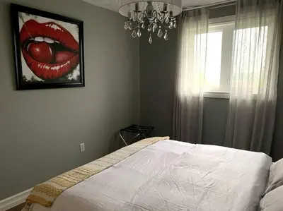 a bedroom with a painting of a mouth on the wall at 4 Bedrms, Indoor HotTub, Wineries & Niagara Falls in Beamsville