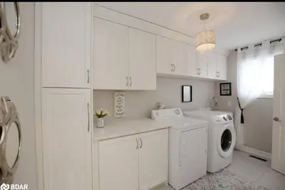 a white kitchen with a washing machine and a washer at 4 Bedrms, Indoor HotTub, Wineries & Niagara Falls in Beamsville