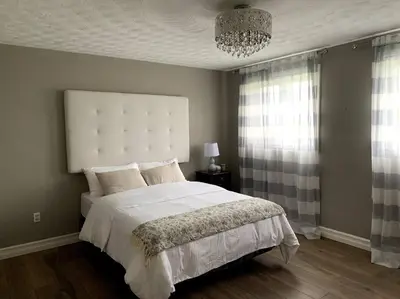 a bedroom with a bed and a chandelier at 4 Bedrms, Indoor HotTub, Wineries & Niagara Falls in Beamsville