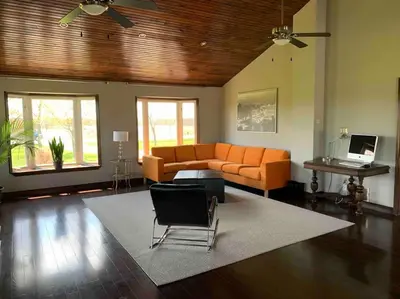 a living room with an orange couch and a table at 4 Bedrms, Indoor HotTub, Wineries & Niagara Falls in Beamsville
