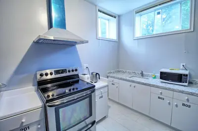 a kitchen with white cabinets and a stove top oven at Bright Basement & Private Bathroom, free Parking in Vaughan