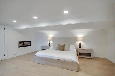 a white bedroom with a bed and two night stands at Lakefront Retreat Hot Tub Outdoor Sauna Dock Swim Stunning Views! in Rosseau