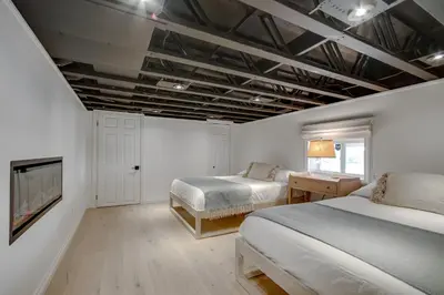 a bedroom with two beds and a fireplace in it at Lakefront Retreat Hot Tub Outdoor Sauna Dock Swim Stunning Views! in Rosseau