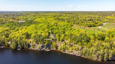 an aerial view of a lake and forest at Lakefront Retreat Hot Tub Outdoor Sauna Dock Swim Stunning Views! in Rosseau