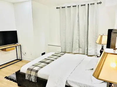 a white bedroom with a bed and a television at LaVida Exclusive Guest House, Free Parking (Rm#2) in London