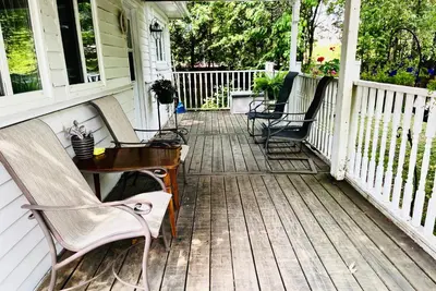 a porch with two chairs and a table on it at Barker House 1# Suite-heart of oldtown in Niagara on the Lake