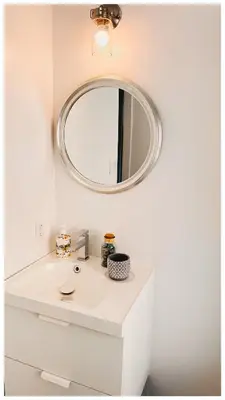 a bathroom with a white sink and a mirror at Cozy Place on Main Floor in Toronto