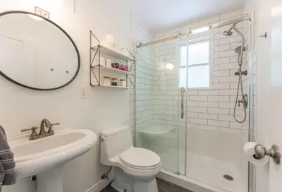 a bathroom with a toilet and a sink and a shower at Waterfront Haliburton, All Season, Fully Equipped Cottage! in Haliburton