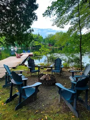 a group of blue chairs and a table and a dock at Waterfront Haliburton, All Season, Fully Equipped Cottage! in Haliburton