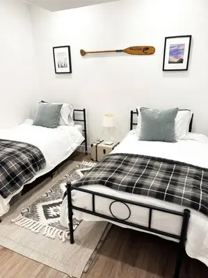 a bedroom with two beds and a bat on the wall at Waterfront Haliburton, All Season, Fully Equipped Cottage! in Haliburton