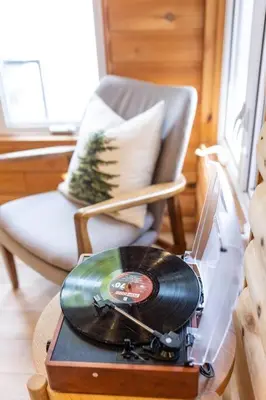a record player sitting on a table next to a chair at Waterfront private cottage on Koshlong Lake in Haliburton