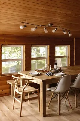 a wooden dining room with a table and chairs at Waterfront private cottage on Koshlong Lake in Haliburton