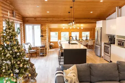 a living room with a christmas tree in a house at Waterfront private cottage on Koshlong Lake in Haliburton