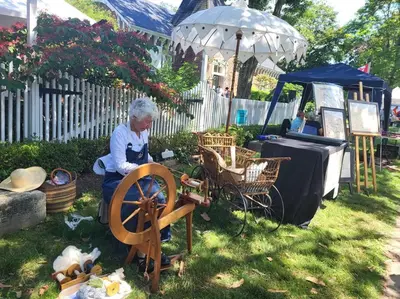 an older woman standing next to a wheel in a yard at Cozy Home in Niagara-on-the-Lake in Niagara on the Lake